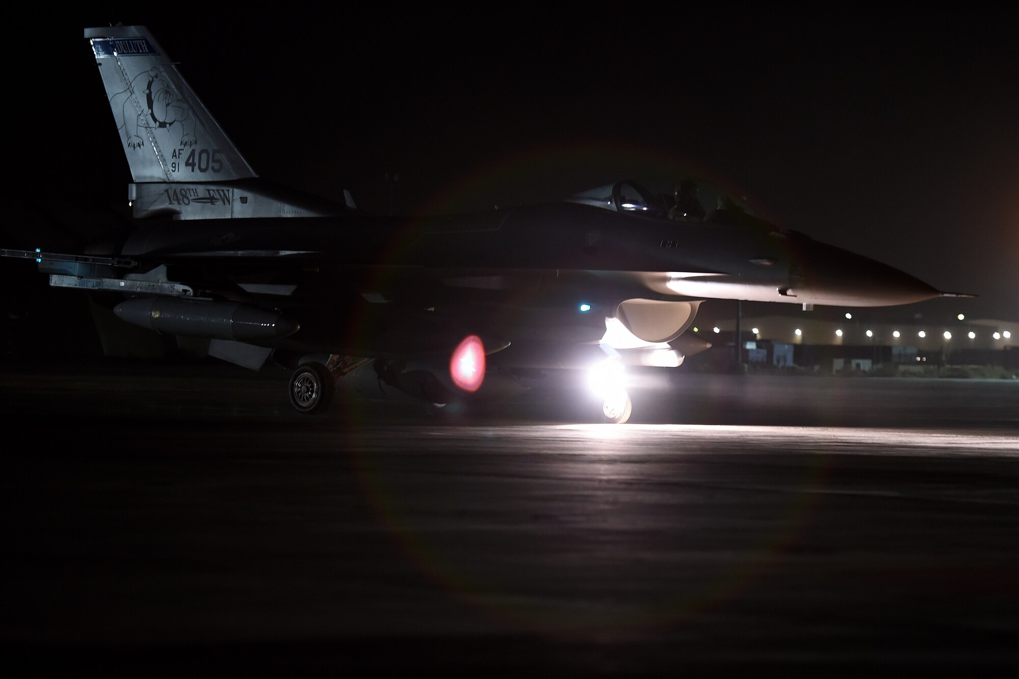an f-16 fighting falcon lands on the runway at night