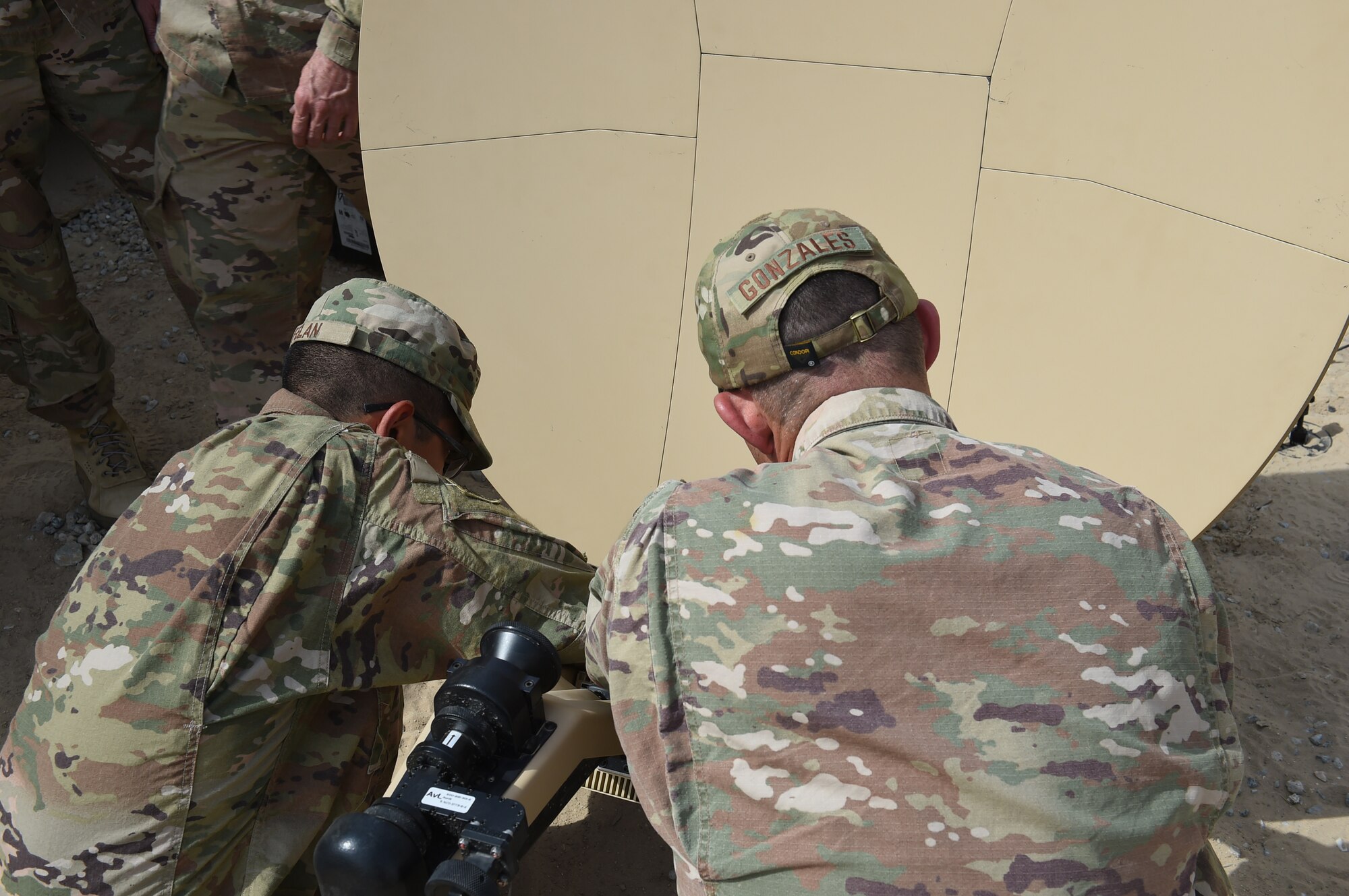 Two deployed Airmen assemble a satellite.