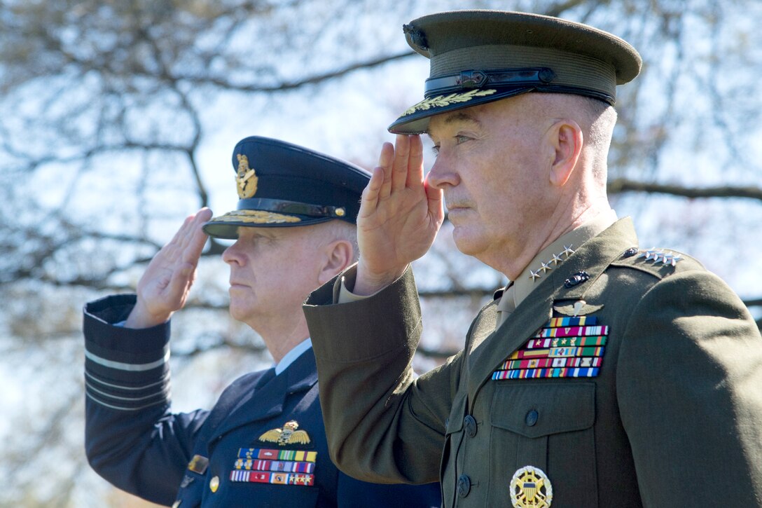 The chairman of the Joint Chiefs of staff and an Australian military official salute.