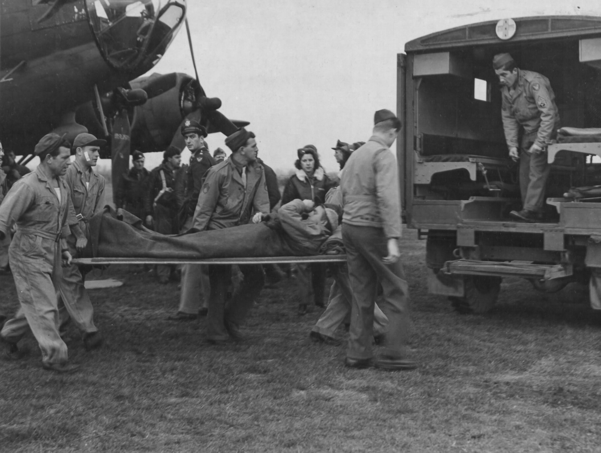 Bombardier 2nd Lt Marion Walshe, wounded in the leg by flak, carried to an ambulance after a mission to Gelsenkirchen, Germany, in November 1943.  After recovery, he continued flying missions only to be shot down and taken prisoner in February 1944.