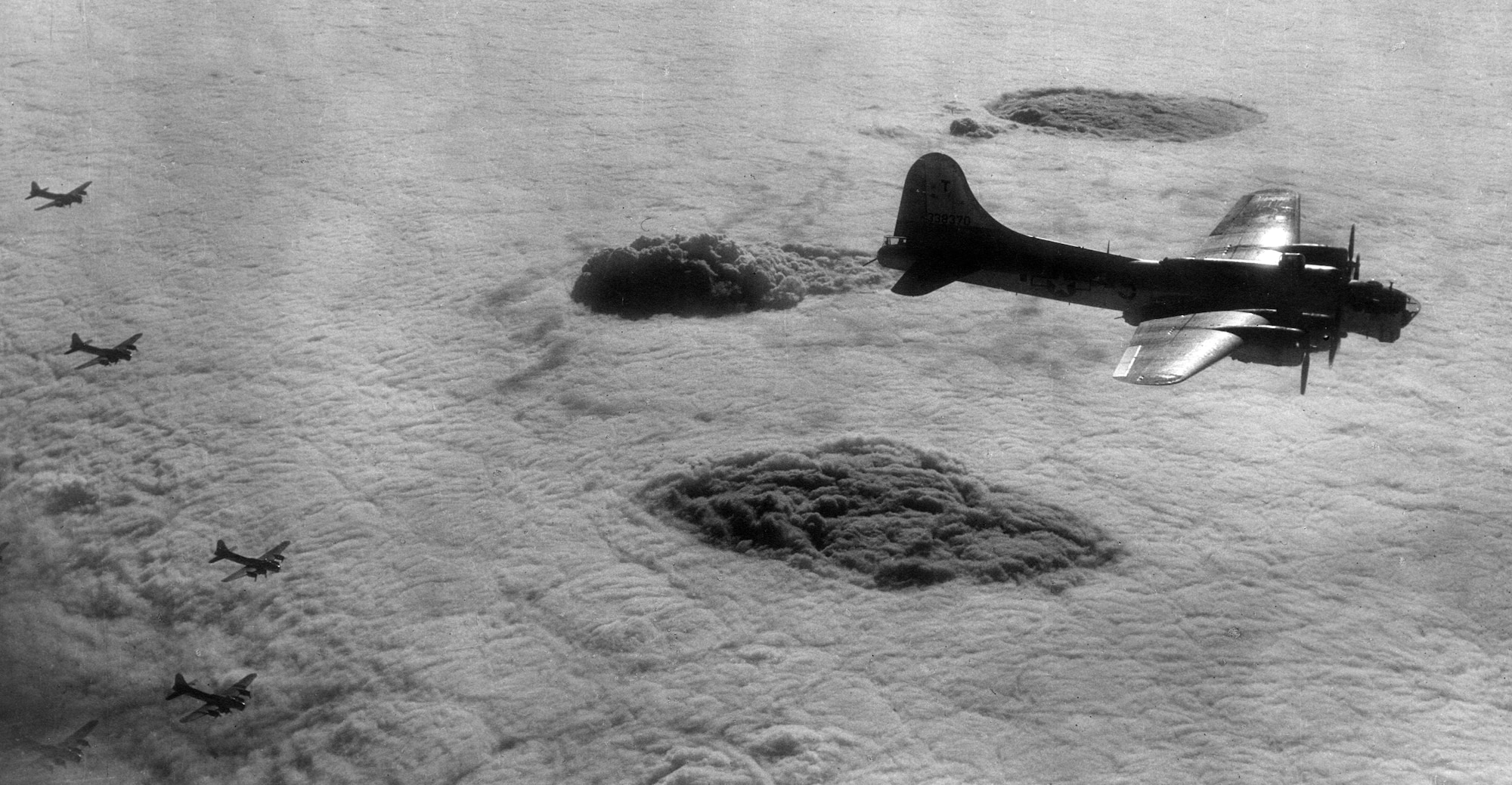 Black smoke boils up through cloud cover from oil refineries at Hamburg, Germany, after an Eighth Air Force blind bombing attack on October 25, 1944.