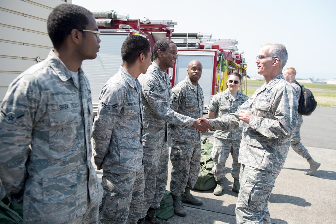 The vice chairman of the Joint Chiefs of Staff shakes hands with airmen.