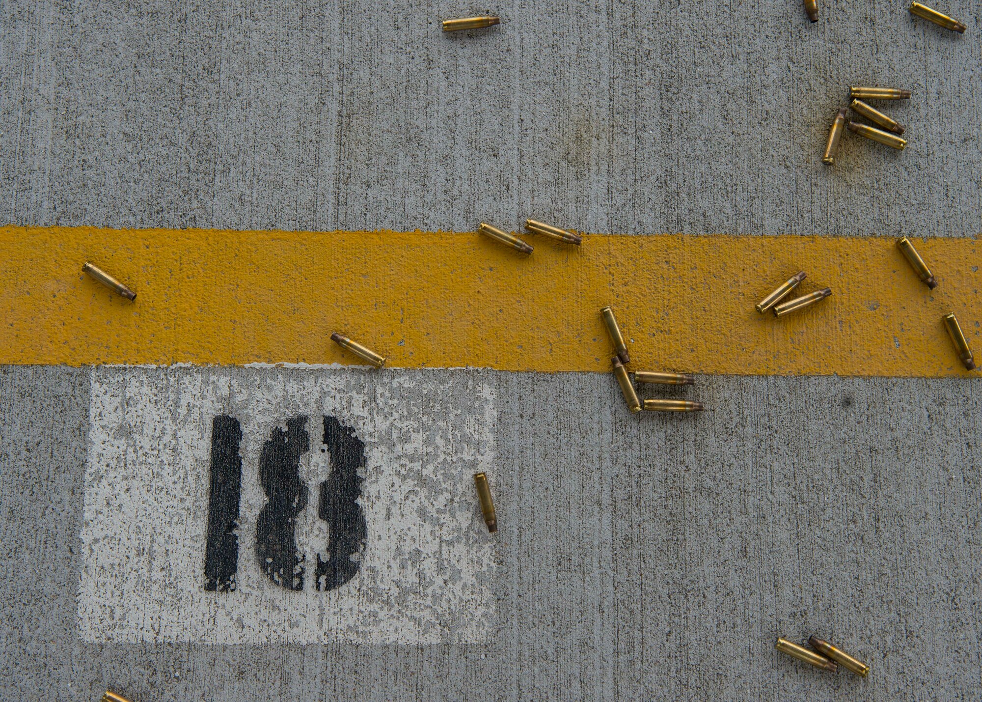 Expended 5.56 mm shell casings from an M4 carbine lay on the new Combat Arms Training and Maintenance outdoor firing range at Draughon Range adjacent Misawa City, Japan, April 18, 2018. Draughon Range facilitates live and inert munitions training for F-16 Fighting Falcon pilots, survival, evasion, resistance and escape training scenarios, explosive ordnance disposal exercises and cargo drops. (U.S. Air Force photo by Staff Sgt. Deana Heitzman)