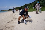 DLA Energy Okinawa employees pick up trash from White Beach