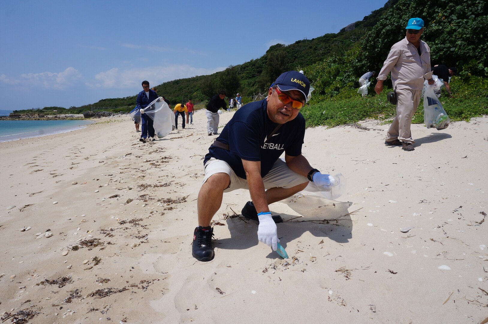 DLA Energy Okinawa employees pick up trash from White Beach