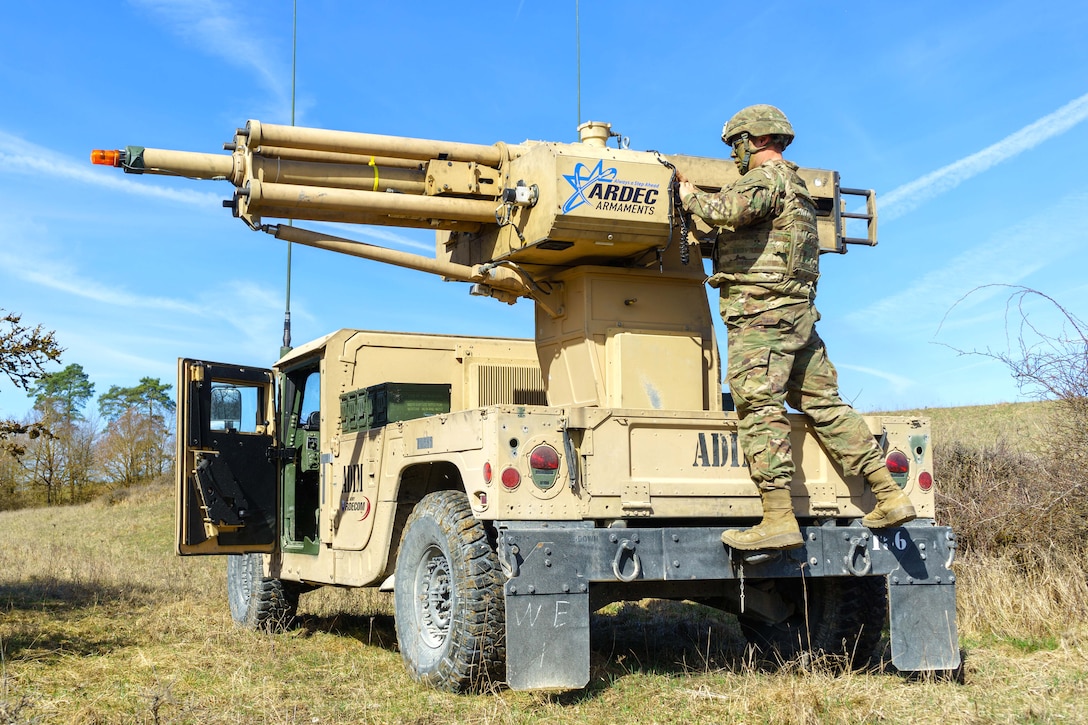 A soldier simulates loading a vehicle-mounted Automated Direct/Indirect Mortar.