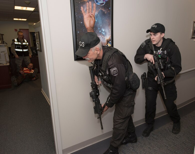 Ralph Marschhausen and Matthew Nolan, Security guards with the 23rd Space Operations Squadron, prepare to clear the 23rd SOPS command section office in Building 100 at New Boston Air Force Station, New Hampshire, April 10, 2018. Marschhausen and Nolan swiftly responded to the active shooter threat exercise scenario, conducted by the 50th Space Wing Inspector General's office during their inspection visit to the wing's geographically separated unit.