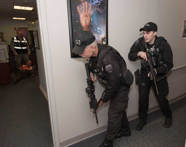 Ralph Marschhausen and Matthew Nolan, Security guards with the 23rd Space Operations Squadron, prepare to clear the 23rd SOPS command section office in Building 100 at New Boston Air Force Station, New Hampshire, April 10, 2018. Marschhausen and Nolan swiftly responded to the active shooter threat exercise scenario, conducted by the 50th Space Wing Inspector General's office during their inspection visit to the wing's geographically separated unit.