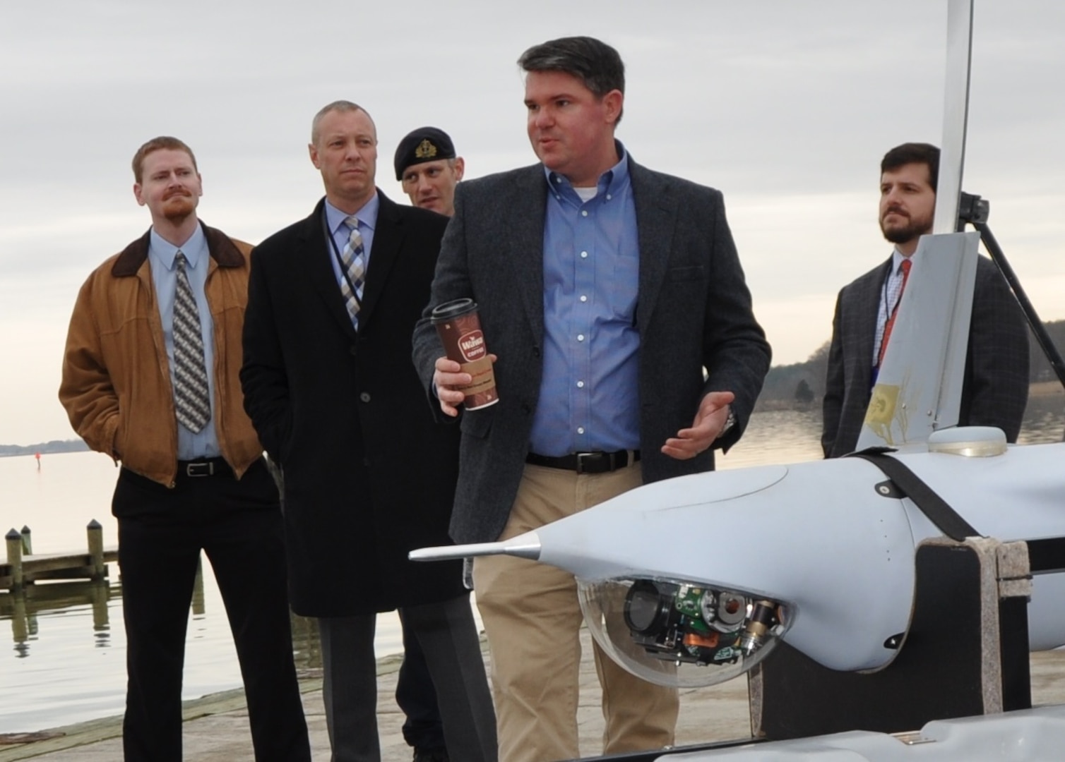 IMAGE: DAHLGREN, Va. (March 28, 2018) - Navy scientist Dr. Chris Weiland briefs visitors on the coordinated use of unmanned aerial vehicles for intelligence and targeting at a demonstration of the Surface and Expeditionary Warfare Mission Module that will be integrated in the developmental Common Unmanned Surface Vehicle (CUSV). The mission module comprises engagement system technology developed by Naval Surface Warfare Center Dahlgren Division coupled with a Battle Management System that controls munitions such as the Longbow Hellfire Missile. The event comes on the heels of a cooperative research and development agreement that NSWCDD signed with Textron Systems who makes the CUSV. The agreement covers the integration of missile, designator, and remote weapon station payloads to the CUSV with its 3,500-pound payload capacity on the deck and a payload bay measuring 20.5 x 6.5 feet.  (