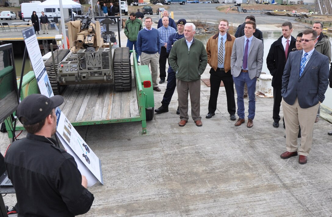 IMAGE: DAHLGREN, Va. (March 28, 2018) - Navy scientist Ben Wheeler briefs visitors on an engagement system integral to the Surface and Expeditionary Warfare Mission Module technologies and weapons toe integrated on the developmental Common Unmanned Surface Vehicle (CUSV). The mission module comprises engagement system technology developed at Naval Surface Warfare Center Dahlgren Division (NSWCDD) coupled with a Battle Management System that controls munitions such as the Longbow Hellfire Missile. The event comes on the heels of a cooperative research and development agreement that NSWCDD signed with Textron Systems who makes the CUSV. The Navy and Textron Systems plan to prove that direct and indirect fire capability with a gunfire demonstration later this year, followed by a live missile shoot in 2019. (U.S. Navy photo/Released)