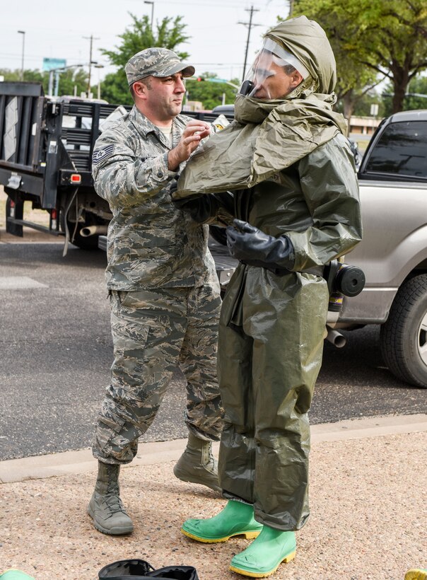 U.S. Air Force Tech. Sgt. Michael Watson, 17th Medical Group dental laboratory noncommissioned office in charge and Airman First Class, Adan Ramirez, 17th MDG family health medical technician, demonstrate the Toxicological Protective Coveralls with a power air purifying respirator hood during a training exercise at the San Angelo Community Medical Center, San Angelo, Texas, April 19, 2018. This equipment is worn by individuals working with patients during the decontamination process. (U.S. Air Force photo by Aryn Lockhart/Released)