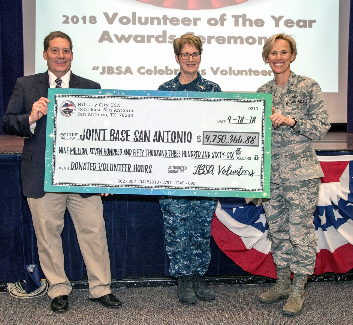 (From left) Robert Naething, deputy to the commanding general, U.S. Army North (Fifth Army); Rear Adm. Rebecca McCormick-Boyle, Navy Medicine Education, Training and Logistics Command commander; and Brig. Gen. Heather Pringle, 502nd Air Base Wing and JBSA commander, hold a mock check which represents the value of volunteer hours to the JBSA community.
