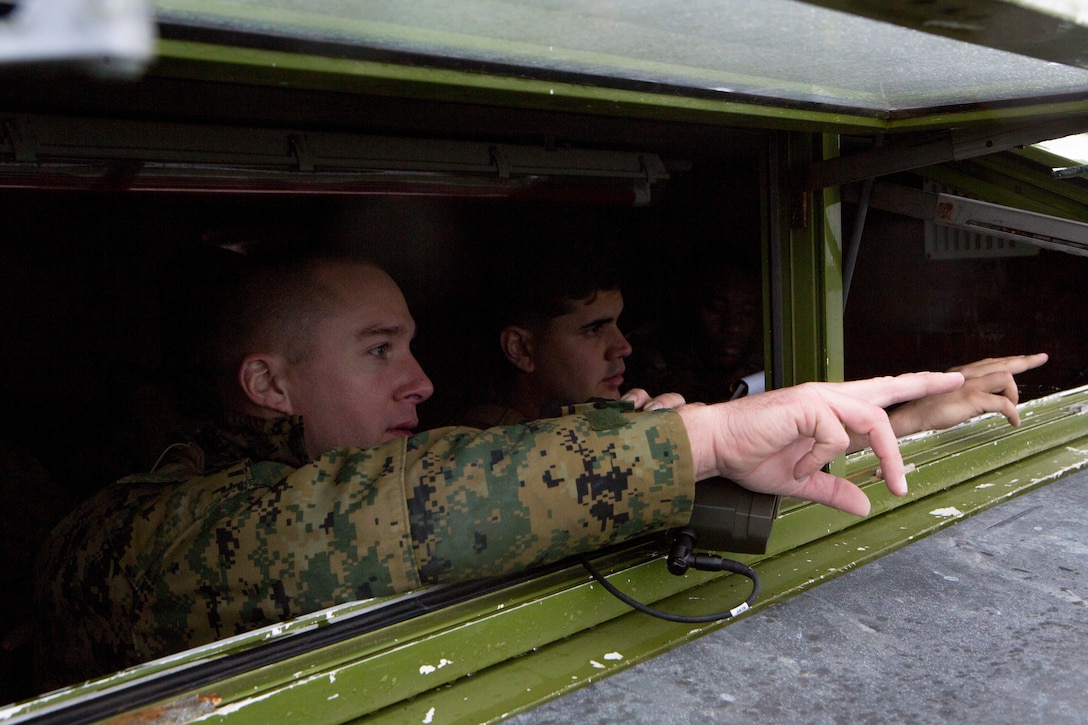 Sgt. Andrew Snow (left), a firepower control team chief with 4th Air Naval Gunfire Liaison Company, Force Headquarters Group, and Cpl. David Rodriguez (right), a forward observer with 4th ANGLICO, FHG, point to the direction of a planned target in Durness, Scotland, April 22, 2018.
