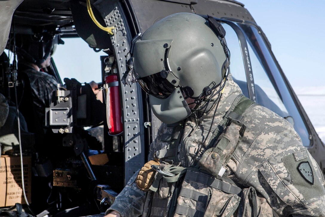 An Army crew chief performs checks on a helicopter.