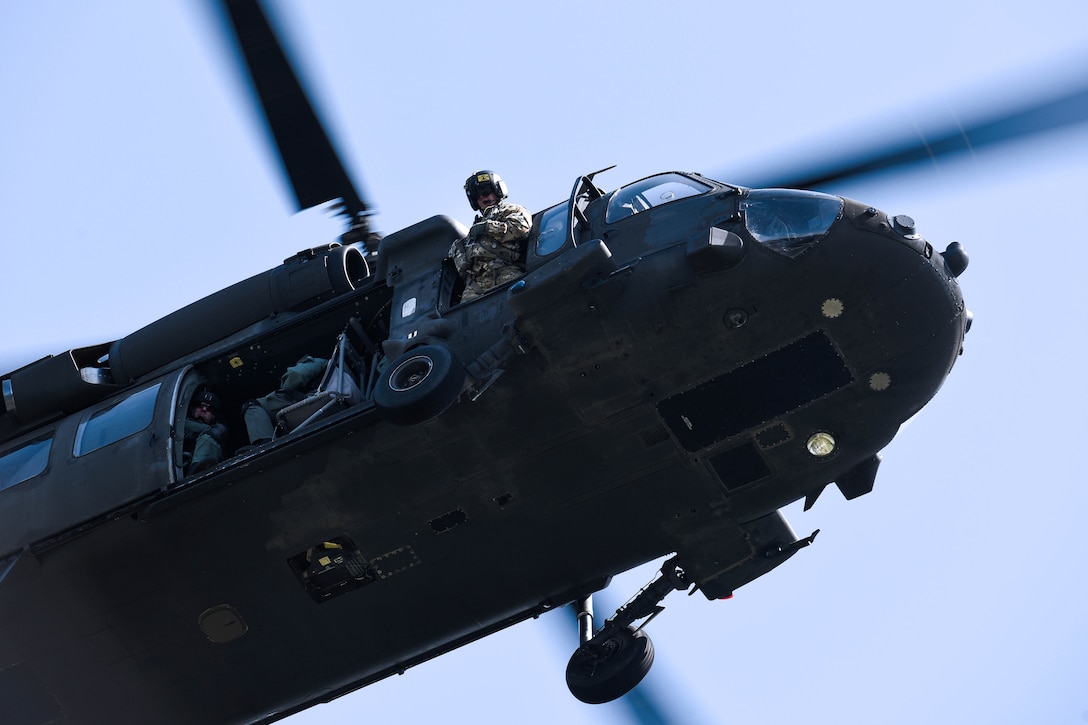 An Army crew chief checks for safe clearance.