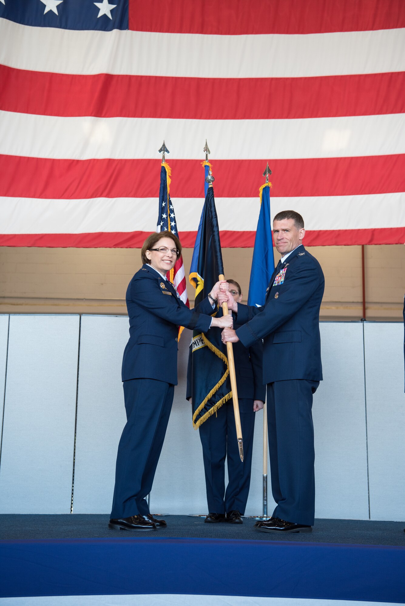 Maj. Gen. Mary O'Brien, 25th Air Force commander, hands the guidon to Col. Andrew Clark, 9th Reconnaissance Wing commander at Beale Air Force Base, California, April 13, 2018. Col. Clark took over command after previously holding the position of vice commander for the 9th RW.