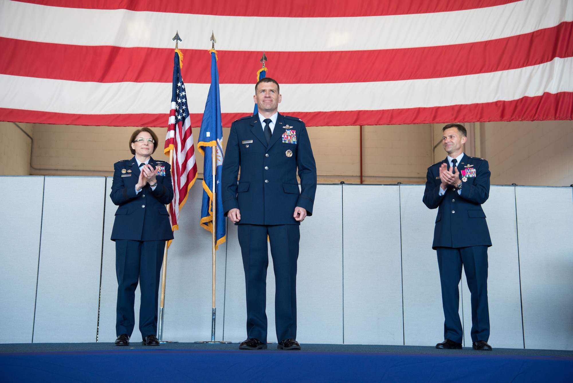 Maj. Gen. Mary O'Brien, 25th Air Force commander, and Col. Larry Broadwell, former 9th Reconnaissance Wing commander, clap for Col. Andrew Clark, 9th RW commander, during the change of command at Beale Air Force Base, California, April 13, 2018. Clark will be responsible for more than 7,000 Airmen and civilians as well as the Air Force's entire high-altitude reconnaissance fleet of RQ-4 Global Hawk and U-2 Dragon lady aircraft.