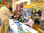 Cindy Dixon and Travis Killen, both seated, listen to an attendee of the Franklin County Chamber of Commerce Business Expo April 5 at the Monterey Station in Cowan. Dixon and Killen are AEDC acquisition professionals at Arnold Air Force Base with the Test Operations and Support contractor. They engaged with local and regional business members about the best way to do business with the Base. The TOS booth was among 83 other business booths. (Courtesy NAS photo by Bob Pullen)