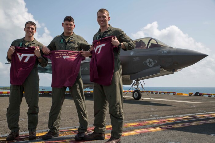 Marine pilots stand on flight deck.