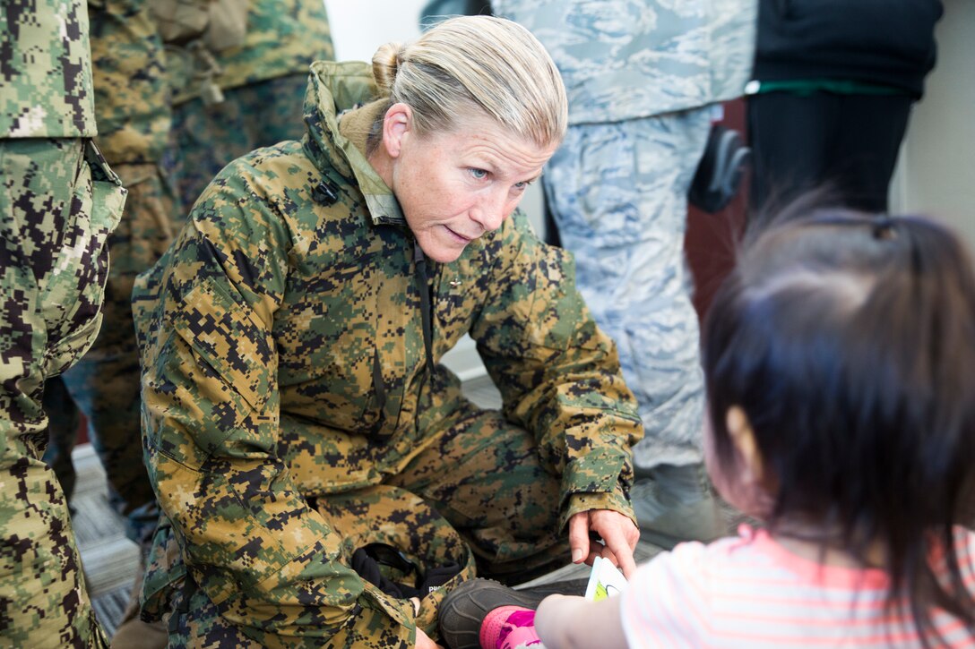 Brig. Gen. Helen G. Pratt, commanding general of 4th Marine Logistics Group, talks with a child from Noatak, Alaska, during Innovative Readiness Training Arctic Care 2018, Noatak, April 21, 2018.