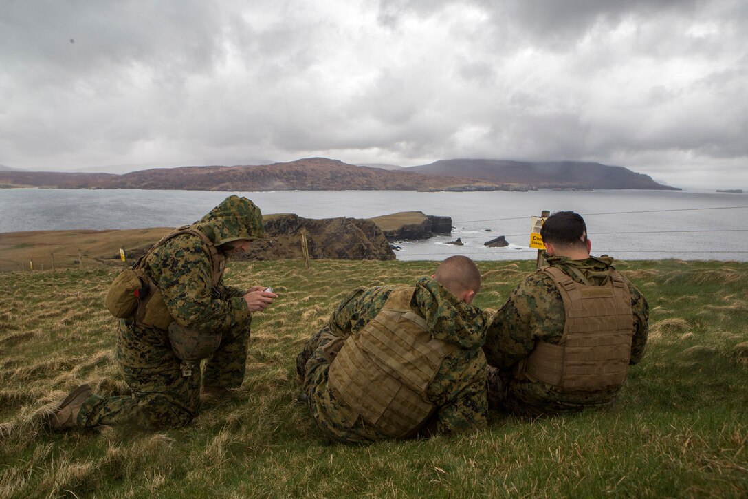 (Right to left) David Rodriguez, a forward observer with 4th Air Naval Gunfire Liaison Company, Force Headquarters Group, and Sgt.'s Andrew Snow and Michael Peers, both firepower control team chiefs with 4th ANGLICO, FHG, discuss and plot coordinates during a practice call-for-fire in Durness, Scotland, April 22, 2018.