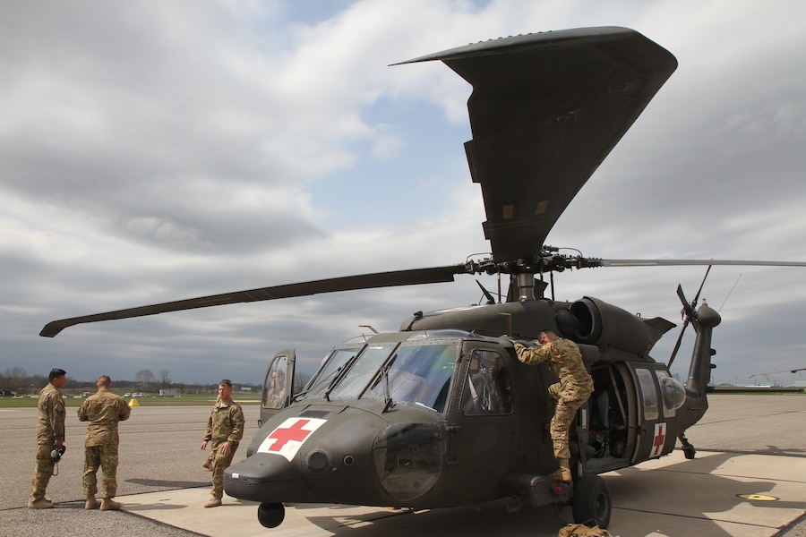 A service member boards a helicopter.