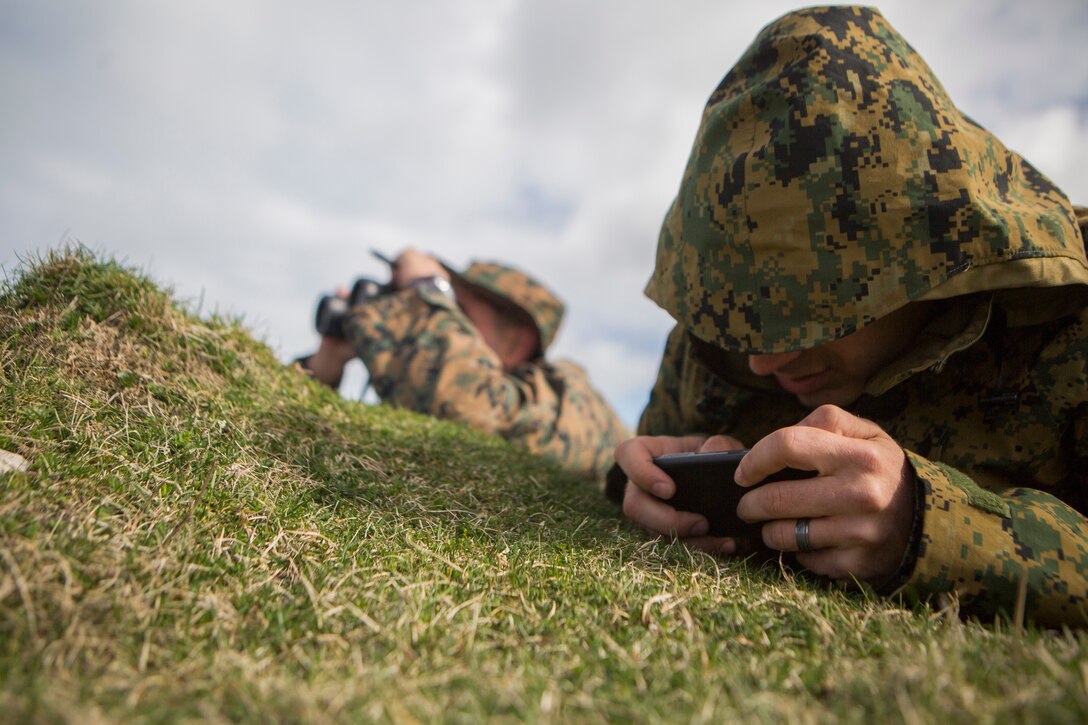 Sgt. Michael Peers (right), a firepower control team chief with 4th Air Naval Gunfire Liaison Company, Force Headquarters Group, uses an Android Tactical Assault Kit to gather target information while Cpl. David Rodriguez (left), a forward observer with 4th ANGLICO, FHG, uses a vector to measure the distance to a possible target, in Cape Wrath, Scotland, April 23, 2018.