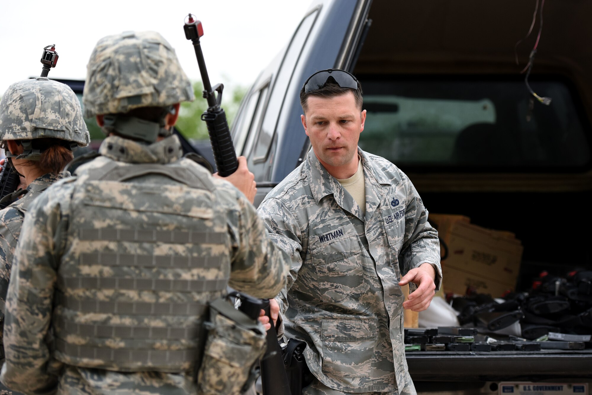 U.S. Air Force Staff Sgt. Zachary Whitman, 17th Security Forces Squadron unit trainer, issues weapons and blank ammunition to cadets at the mock forward operating base on Goodfellow Air Force Base, Texas, April 20, 2018. Proper weapon handling techniques was one of the areas covered in the training exercise. (U.S. Air Force photo by Airman 1st Class Seraiah Hines/Released)
