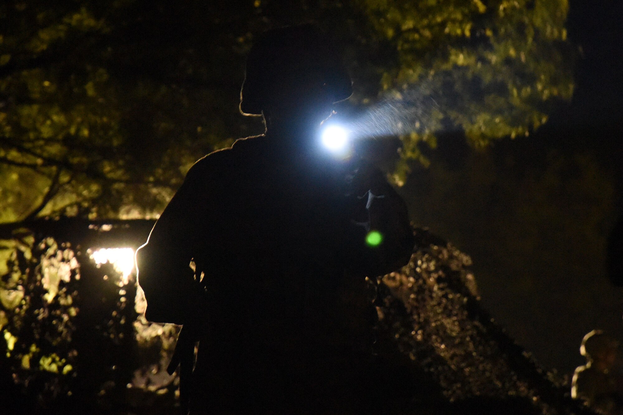 A ROTC cadet from Angelo State University practices nighttime entry controller procedures during the training exercise held at the mock forward operating base on Goodfellow Air Force Base, Texas, April 20, 2018. During the night there was constant simulated bombs, gunfire and shouting. (U.S. Air Force photo by Airman 1st Class Seraiah Hines/Released)