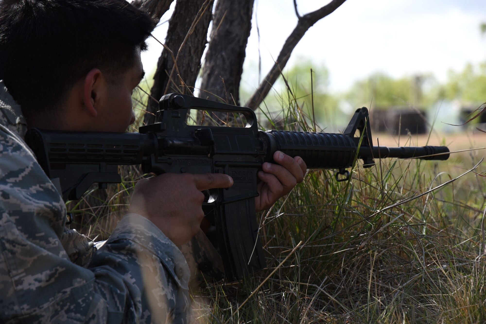Johnny Martinez, Angelo State University Air Force ROTC cadet, takes cover waiting for his team to move up and accomplish the current objective at the mock forward operating base on Goodfellow Air Force Base, Texas, April 21, 2018. Some objectives involved multiple fire teams where the cadets had to organize and coordinate through communication skills taught earlier. (U.S. Air Force photo by Airman 1st Class Seraiah Hines/Released)