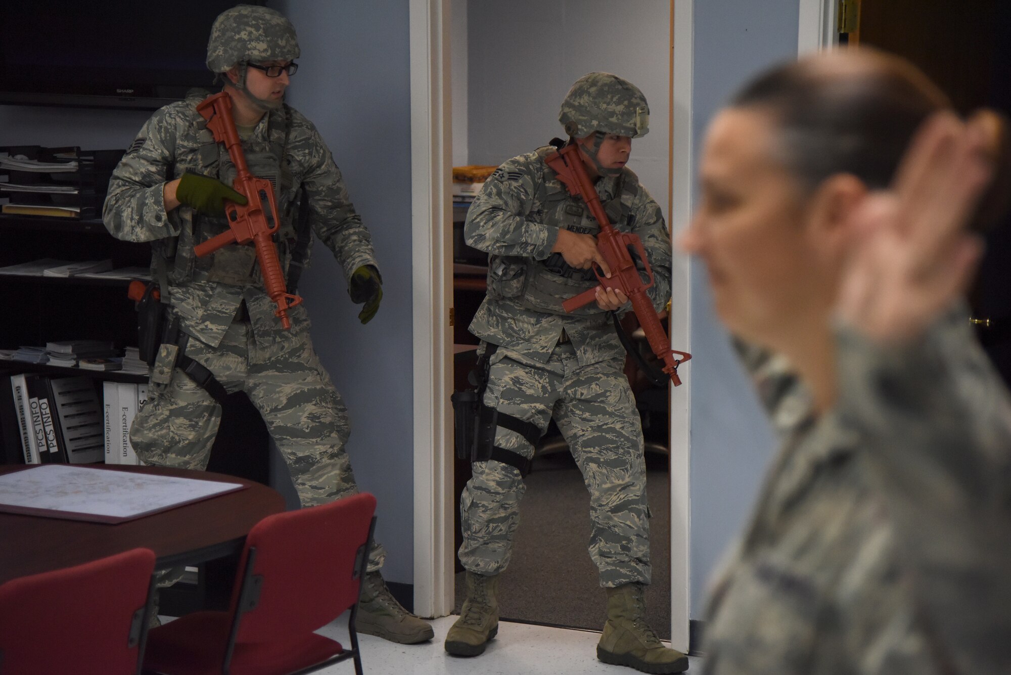 U.S. Air Force Staff Sgt. Sean Miller, 81st Security Forces Squadron base defense operations center controller, left, and Senior Airman Joshua Mendez, 81st SFS patrolman, clear a room during an active shooter exercise at Bryan Hall at Keesler Air Force Base, Mississippi, April 19, 2018. The wing inspection team had an active duty Air Force member simulate opening fire at the Levitow Training Support Facility in order to test the base’s ability to respond and recover from a mass casualty event.  (U.S. Air Force photo by Kemberly Groue)