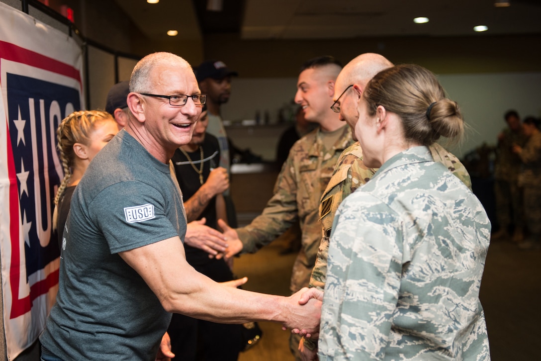 Celebrity chef Robert Irvine shakes hands with a service member.