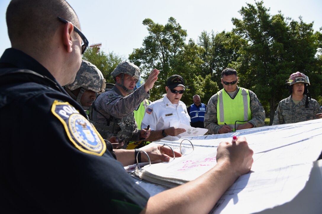 U.S. Air Force Tech. Sgt. Joshua Foster, 81st Security Forces Squadron alpha flight chief, gives a briefing during an incident command change over during an active shooter exercise at Keesler Air Force Base, Mississippi, April 19, 2018. The wing inspection team had an active duty Air Force member simulate opening fire at the Levitow Training Support Facility in order to test the base’s ability to respond and recover from a mass casualty event. (U.S. Air Force photo by Kemberly Groue)