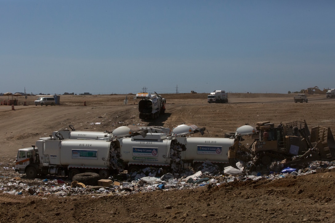 Dump trucks empty trash into a pit where the waste will be converted into energy and used on the installation at the landfill on Marine Corps Air Station Miramar, Calif., April 10.  MCAS Miramar sources 54% of its total energy consumption from on-site renewable energy sources, such as the landfill.  (U.S. Marine Corps photo by Cpl. Victor Mincy/Released)