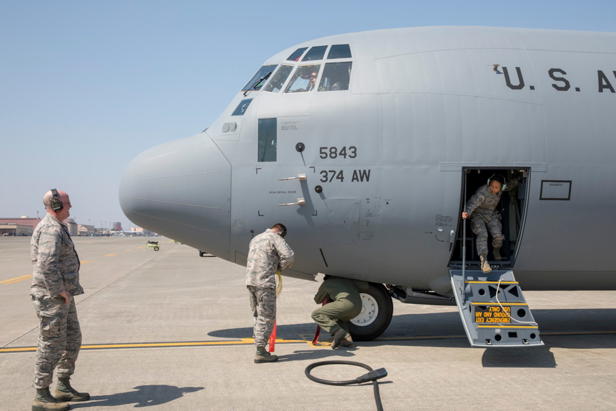Maj. David Mueller, left, 374th Aircraft Maintenance Squadron commander, waits to greet his fellow Airmen coming back from Lockheed Matin Aeronautics Company, Ga., at Yokota Air Base