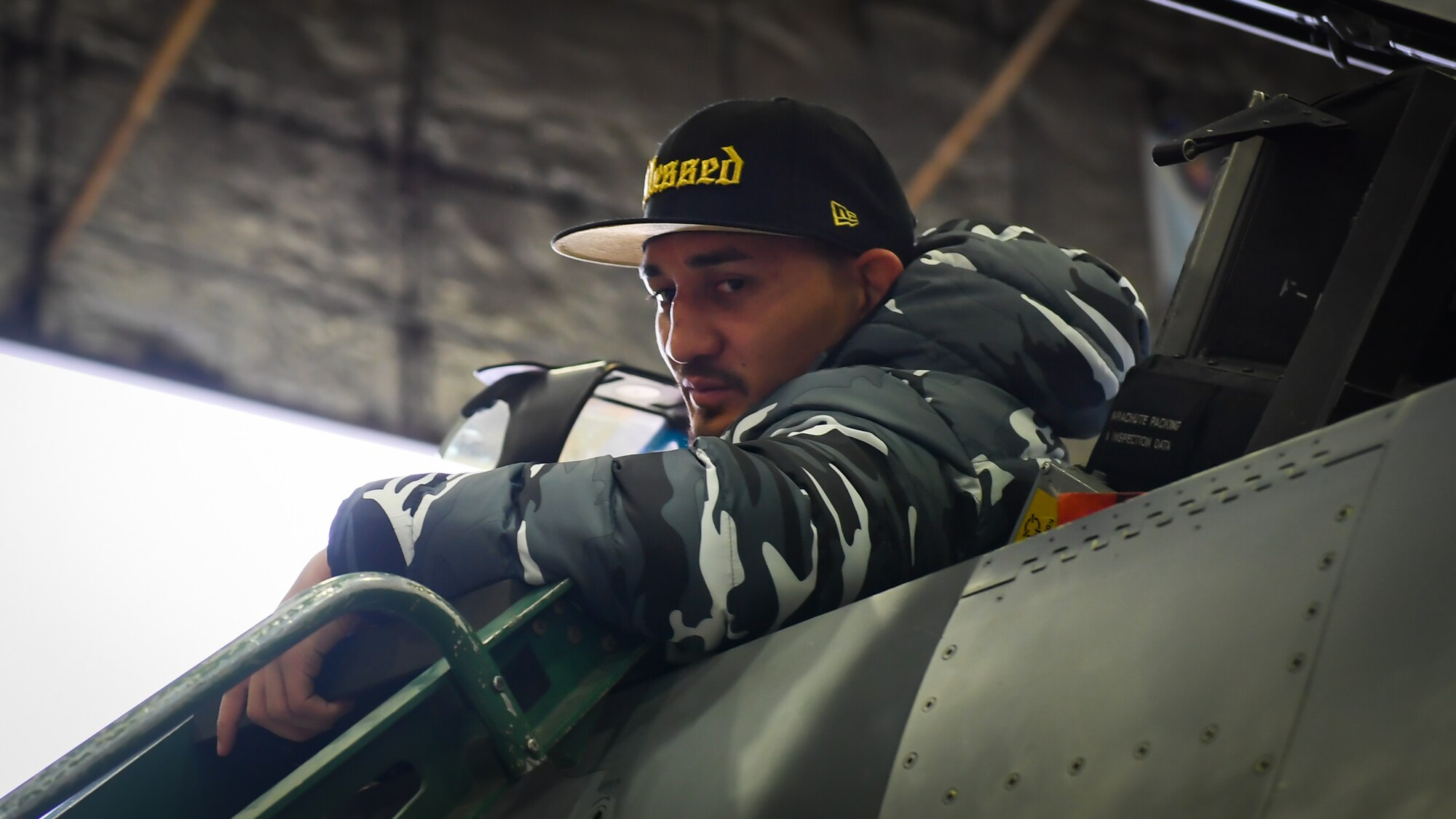 Max Holloway, Ultimate Fighting Championship featherweight champion, looks out of the cockpit of an F-16 Fighting Falcon during a USO tour at Osan Air Base, Republic of Korea, April 23, 2018.
