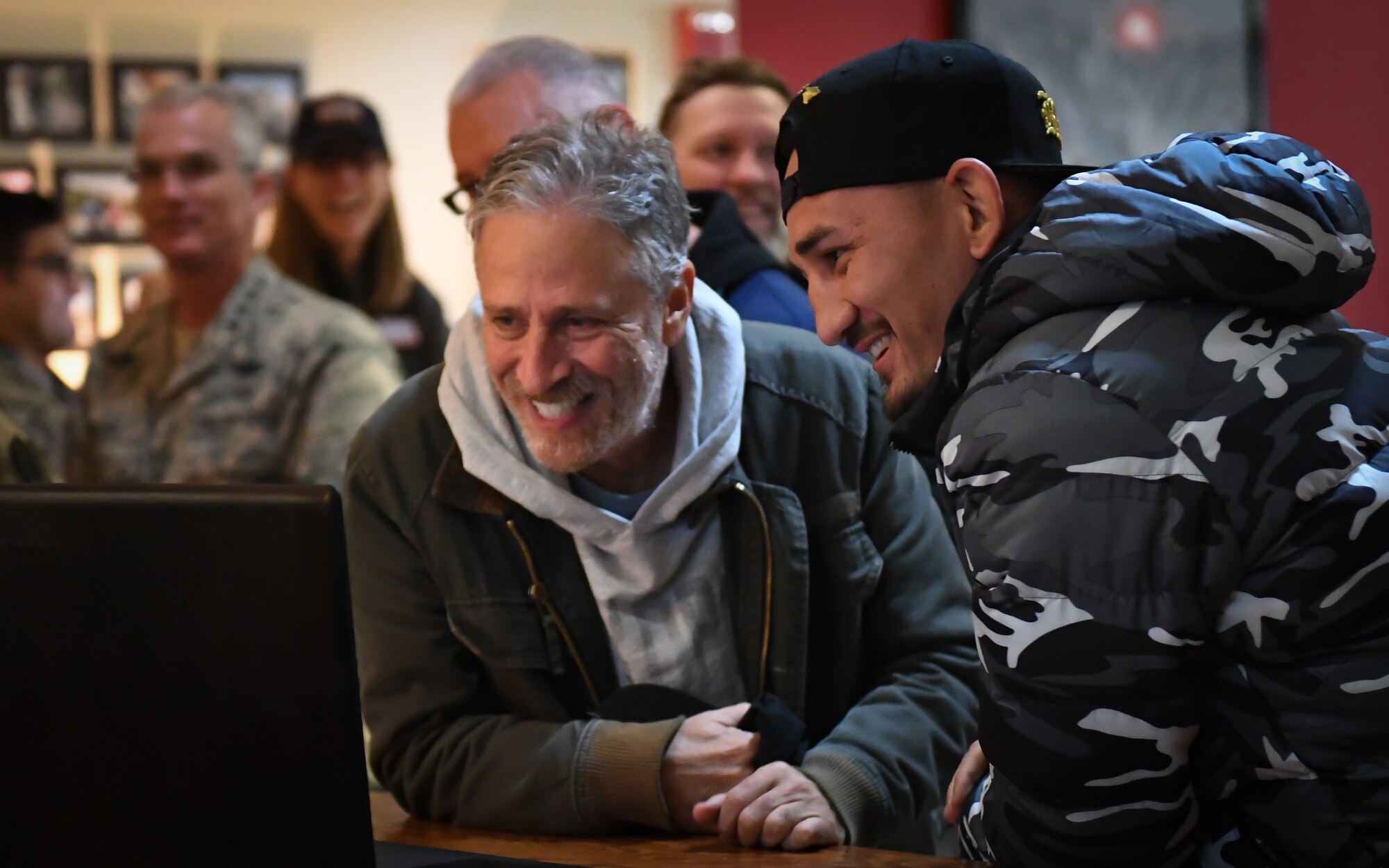 Comedian Jon Stewart and Ultimate Fighting Championship featherweight champion Max Holloway, talk to an Airman's family via Skype during an Airman's surprise birthday celebration at Osan Air Base, Republic of Korea, April 23, 2018.