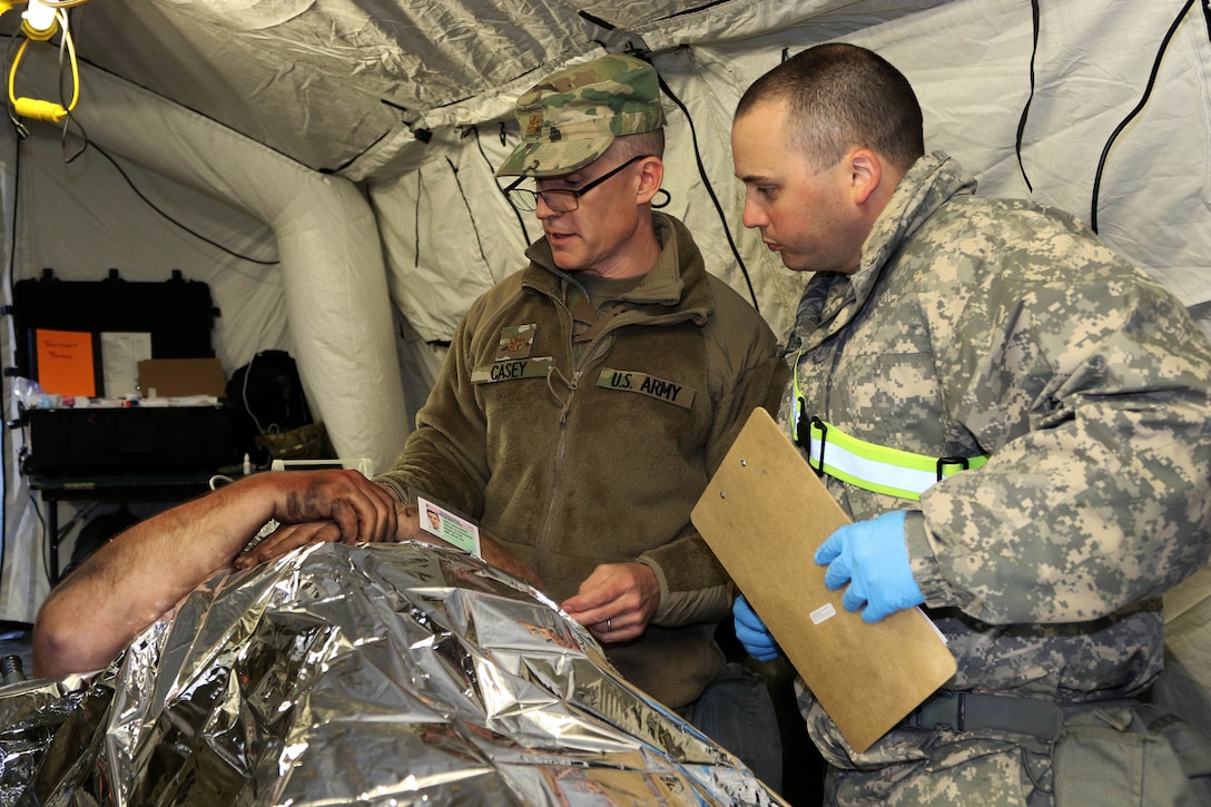 Army medics provide medical aid to a mock patient.