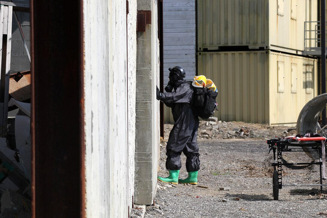 A soldier prepares to enter a building to search for casualties.