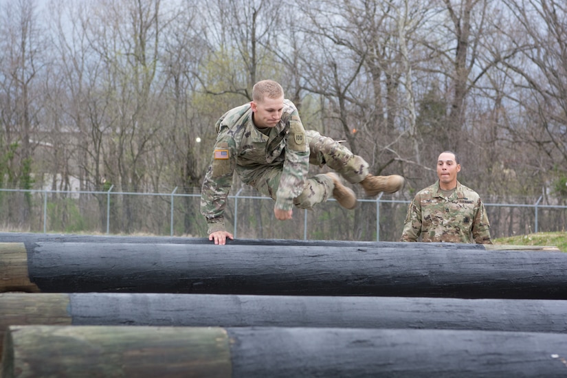 Staff Sgt. Ethan Kruger, with the Camp Parks Noncommissioned Officer Academy,  83rd U.S. Army Reserve Readiness Training Center, 100th Training Division, makes jumping logs look easy as he maneuvers through the obstacle course at the 80th Training Command's 2018 Best Warrior Competition at Fort Knox, Kentucky, April 14, 2018.  His sponsor (background) stays with Kruger throughout the entire competition. (U.S. Army Reserve photo by Maj. Addie Leonhardt, 80th Training Command)