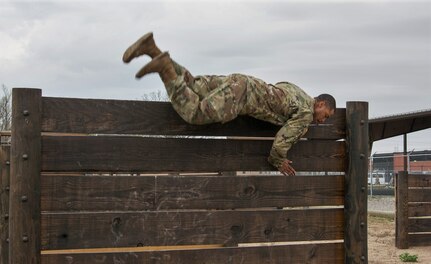 Staff Sgt. DeMarko Snow, assigned to Fort Dix Noncommissioned Officer Academy, 83rd U.S. Army Reserve Readiness Training Center, 100th Training Division, flips himself over a wall in the obstacle course portion of the 80th Training Command's 2018 Best Warrior Competition at Fort Knox, Kentucky, April 14, 2018. (U.S. Army Reserve photo by Maj. Addie Leonhardt, 80th Training Command)