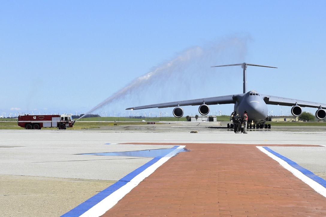 A fire truck hoses down the last C-5M Super Galaxy.