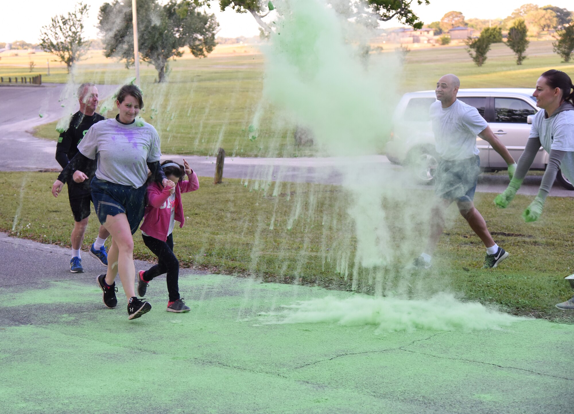 Keesler personnel run through green powder during the Air Force Assistance Fund Color Run at Keesler Air Force Base, Mississippi, April 20, 2018. The AFAF raises funds for charitable affiliates that provide support to Air Force families in need. (U.S. Air Force photo by Kemberly Groue)