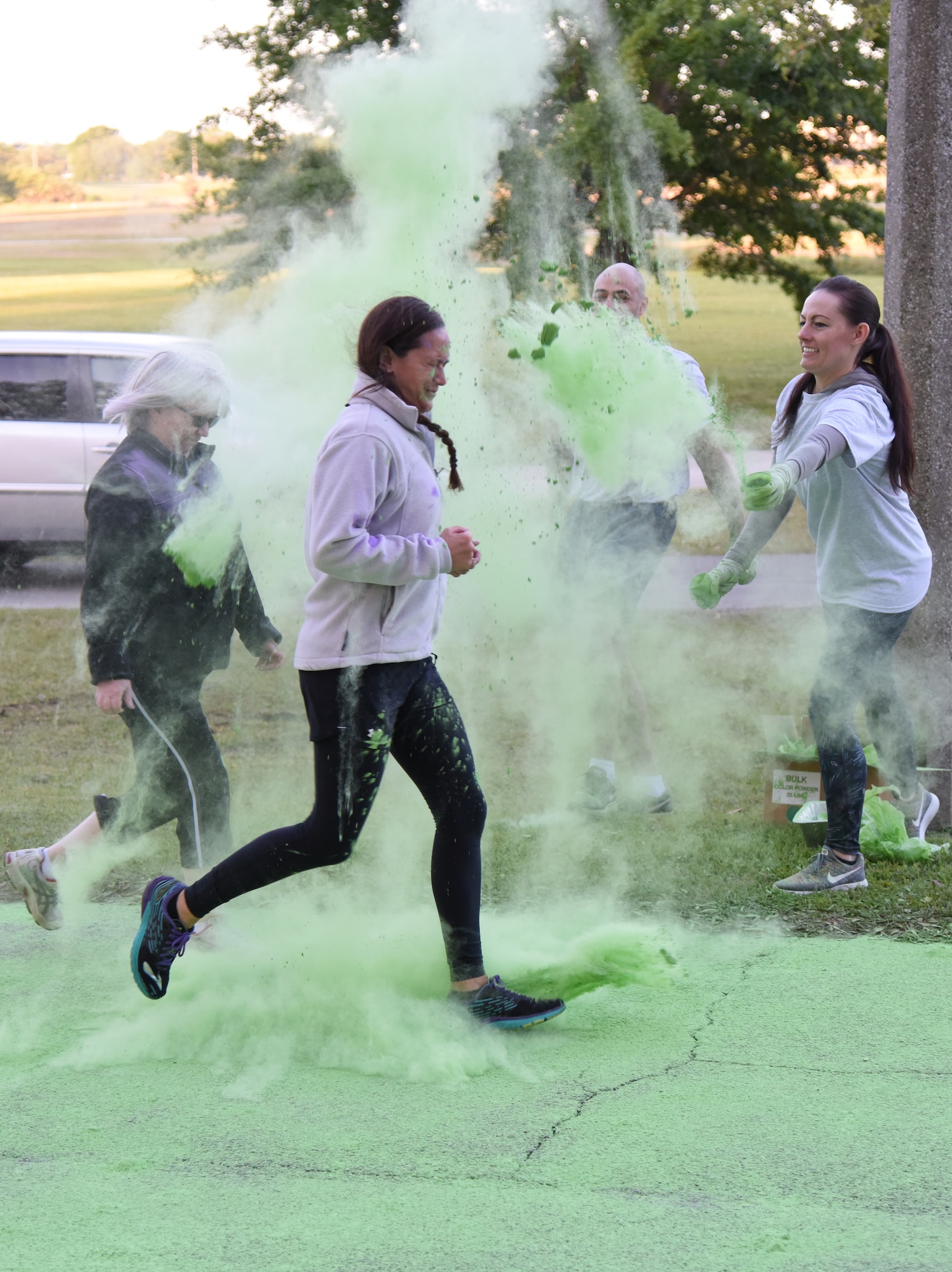 Jackie Pope, 81st Force Support Squadron Airman and Family Readiness Center chief, and U.S. Air Force Lt. Col. Melissa Rativa, 81st Logistics Readiness Squadron commander, run through green powder during the Air Force Assistance Fund Color Run at Keesler Air Force Base, Mississippi, April 20, 2018. The AFAF raises funds for charitable affiliates that provide support to Air Force family in need. (U.S. Air Force photo by Kemberly Groue)