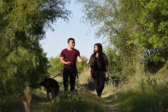 Airman 1st Class Robby Agustin, 47th Operation Support Squadron aircrew flight equipment assistant, Irish Domingo, his spouse, and their dog Momo explore the nature trails at Laughlin Air Force Base, April 23, 2018. The couple enjoys the trails as an alternate to visiting the gym, as well as an opportunity for family time. (U.S. Air Force photo by Airman 1st Class Anne McCready)