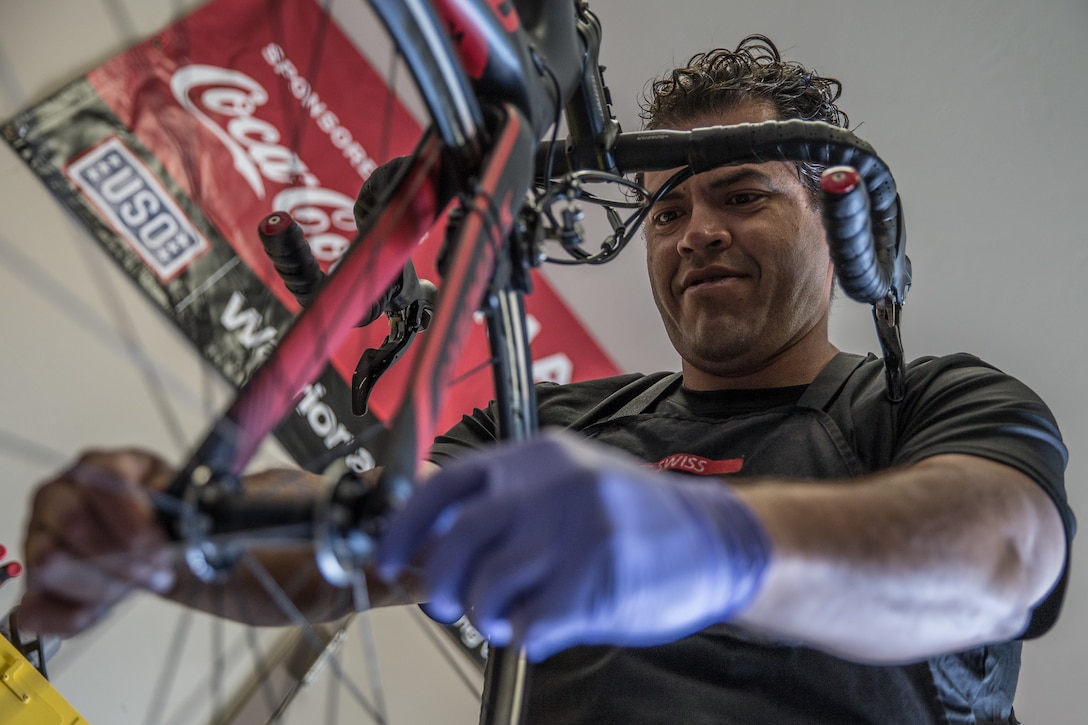 Retired U.S. Marine Corps Master Sgt. Fernando Andrade, a volunteer and bicycle technician with Wounded Warrior Battalion-West, Wounded Warrior Regiment, installs a tire on a bicycle on Marine Corps Base Camp Pendleton, Calif., April 17, 2018. Throughout the year, athletes with the unit compete in the Marine Corps Trials, the Department of Defense Warrior Games, and cycling tours in San Diego; therefore Andrade’s maintenance is vital to each competitors’ success. (U.S. Marine Corps photo by Lance Cpl. Dalton Swanbeck)