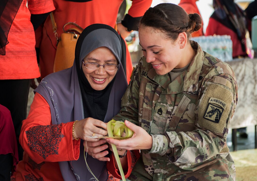 A soldier learns how to make Ketupat.