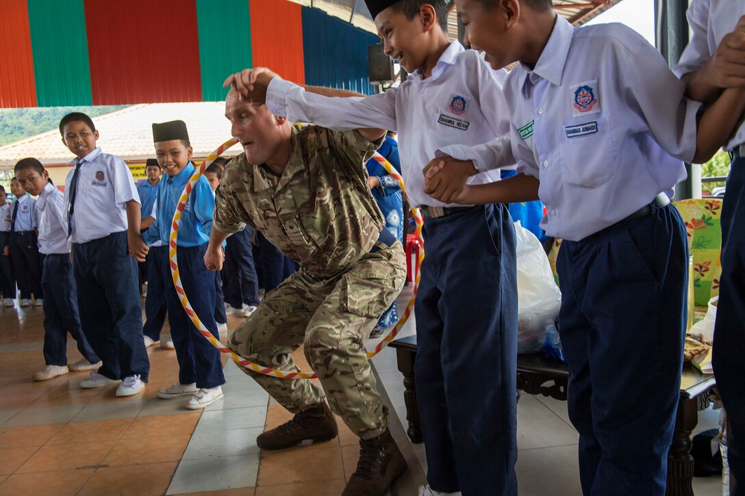 A Royal Navy officer plays games with students.