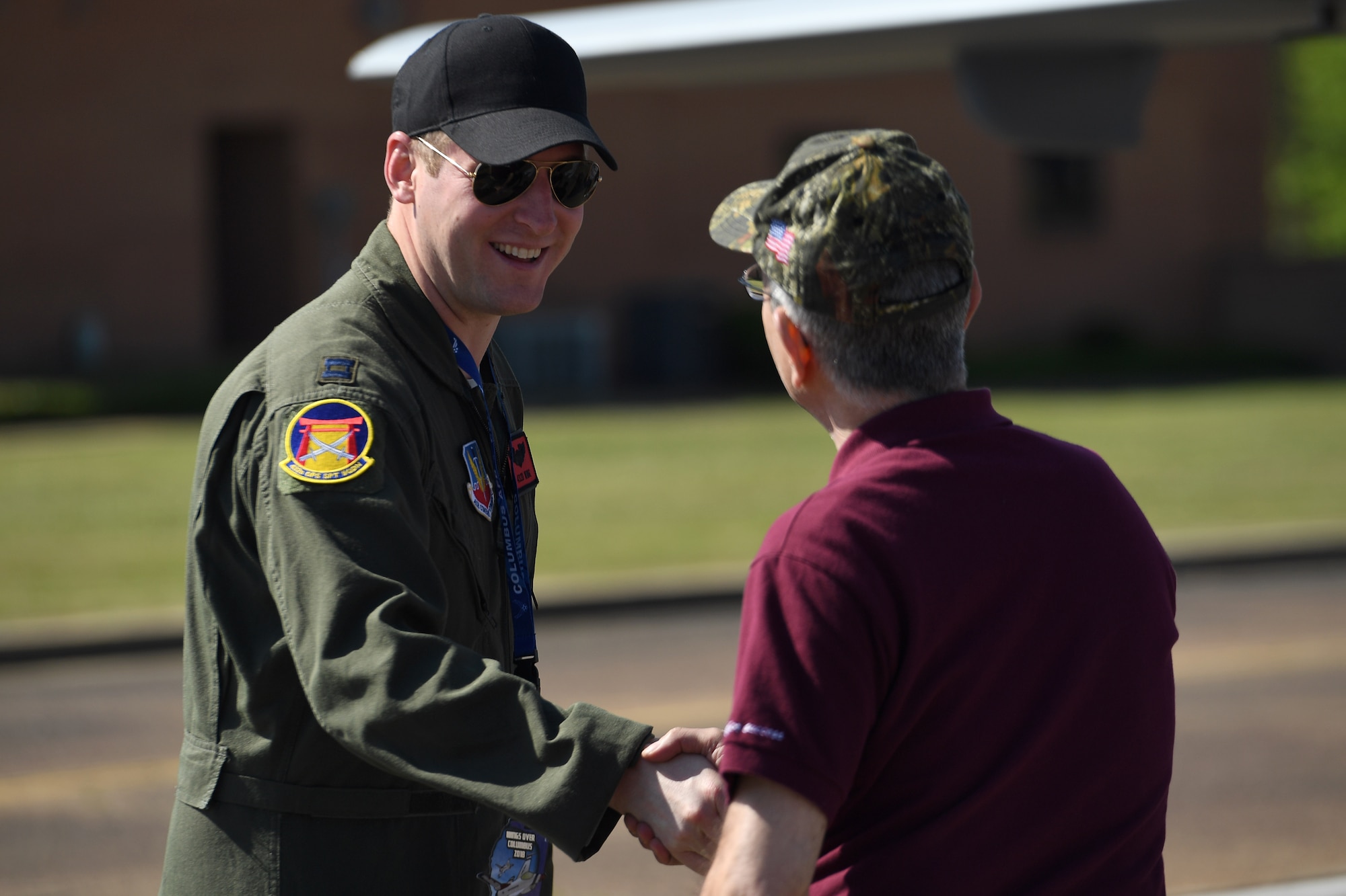 An MQ-9 Reaper pilot assigned to the 432nd Wing/432nd Wing shakes the hand of a visitor during the 2018 Wings Over Columbus Air and Space Expo April 21, 2018 at Columbus Air Force Base, Mississippi. MQ-9 aircrew communicated the 432nd WG/432nd AEW mission and explained how Airmen exploit the MQ-9’s persistent attack capabilities to deliver justice to those who wish harm.  (U.S. Air Force photo by Senior Airman James Thompson)