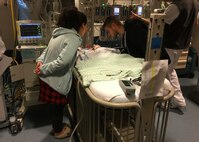 Ashley Mockovciak, Team Shaw spouse, left, and Tech. Sgt. Ben Mockovciak, 372nd Training Squadron Detachment 202 F-16 tactical aircraft maintenance instructor, lean over their son Noah’s bed at a hospital at Charleston, S.C., circa February 2017.